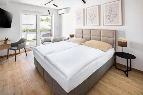 皮耶什佳尼VI&LA - Apart House的卧室配有一张白色大床和一张书桌