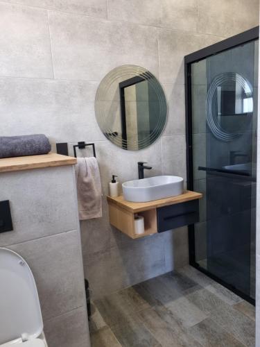 克拉伦斯Villa 206 Clarens Golf Estate的一间带水槽和镜子的浴室