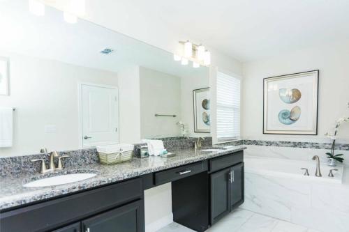 达文波特Modern Vacation Home with Private Pool CG1593的一间带两个盥洗盆和大镜子的浴室