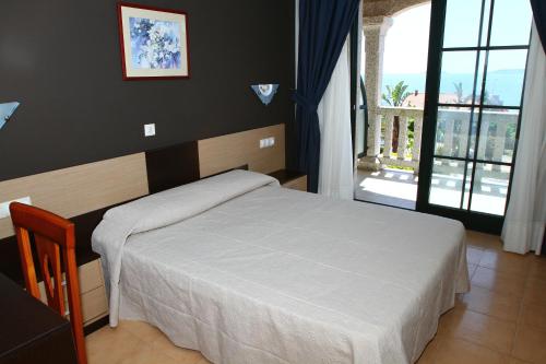 波多诺伏Apartamentos Coral Do Mar II的卧室设有白色的床和大窗户