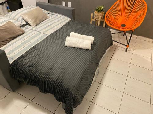 大坎皮纳Flat próximo ao Centro de CG com Wifi rápida的一张带黑色毯子和橙色风扇的床