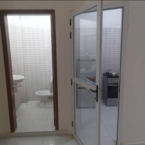 圣路易斯Salam的一间带卫生间和玻璃门的浴室