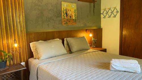 伦索伊斯Vila Verde Perto的一间卧室配有带白色床单和枕头的床。