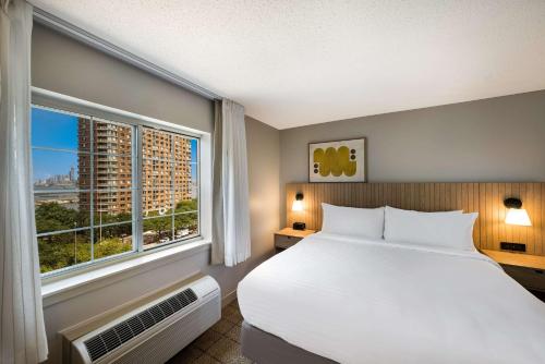 泽西市Sonesta Simply Suites Jersey City的一间卧室设有一张大床和一个大窗户