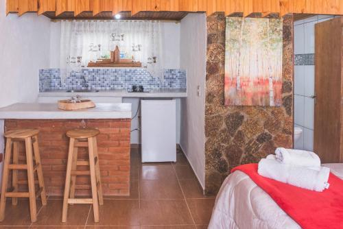 蒙特韦尔迪Chales Boa Vista的带酒吧的厨房和客房内的一张床