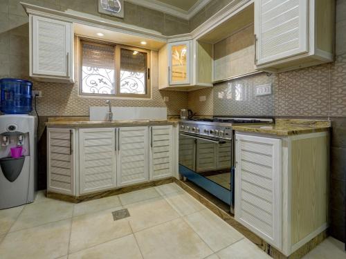 亚喀巴ENG-Murjan Apartment的厨房配有白色橱柜和炉灶烤箱。