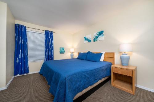 林肯市Waters Edge 402的一间卧室配有蓝色的床和蓝色窗帘