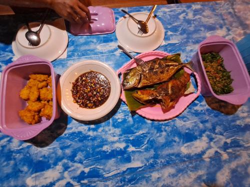 BesirGAM BAY bungalow's的餐桌,盘子上放着食物和碗