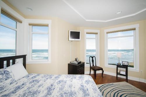 新港Michael's Beach Place @ Shoreline Ridge的一间卧室设有一张床和海景窗户。