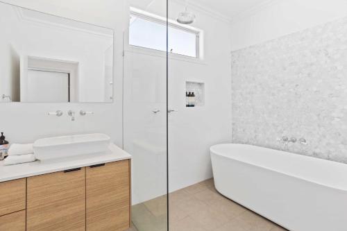 黄金海岸Perfect Palm Beach Townhouse - Hosted by Burleigh Letting的白色的浴室设有浴缸和水槽。