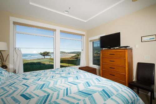 新港Lighthouse View at Shoreline Ridge的一间卧室配有一张床、一台电视和一个窗口