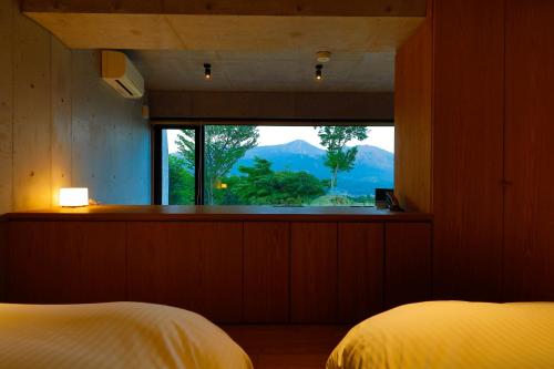 南阿苏村科诺玛玛日式旅馆的卧室设有山景窗户