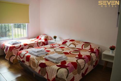 Juana Koslay Seven Hotel - Juana Koslay San Luis的一间卧室配有两张带毛巾的床