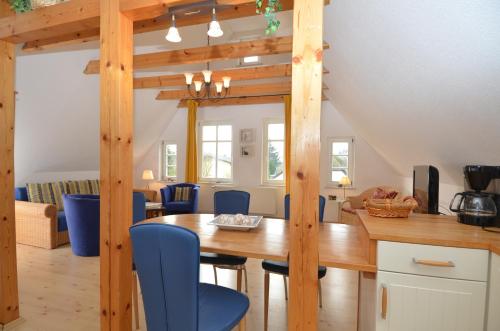 奥斯赛拜-塞林Alte Büdnerei - Apt. 02的厨房以及带木桌和蓝色椅子的用餐室。