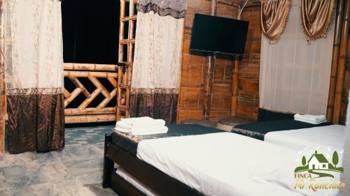 佩雷拉Alojamiento Campestre Finca Mi Ranchito的小木屋内带两张床的房间