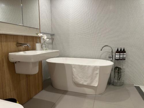 堪培拉Palko - Stylish in the City的浴室配有盥洗盆、浴缸和盥洗盆
