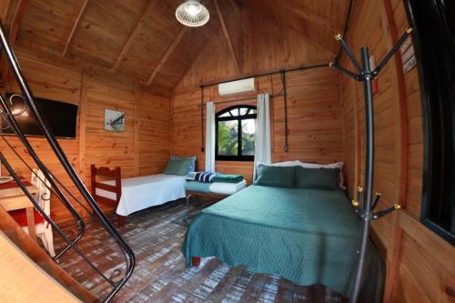 ApiúnaChalé Alpino的小木屋内一间卧室,配有一张床
