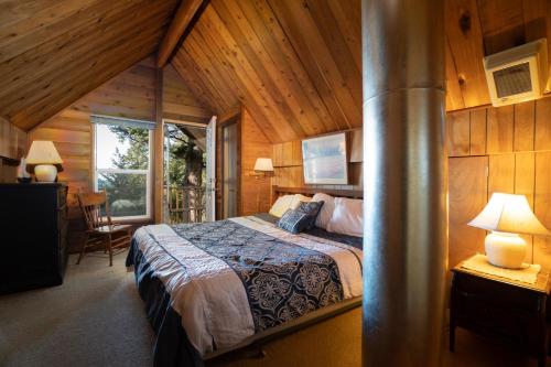 Otter RockThe Cedar House的小木屋内一间卧室,配有一张床