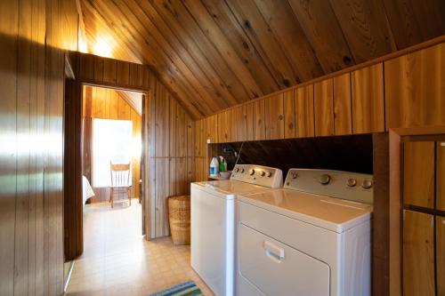Otter RockThe Cedar House的木墙房间内的洗衣机和烘干机