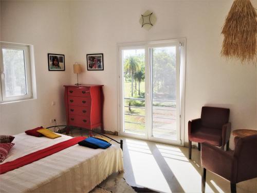 皮里韦维Residencia de Coco, Künstlerhaus in Piribebuy,的卧室配有床、椅子和窗户。
