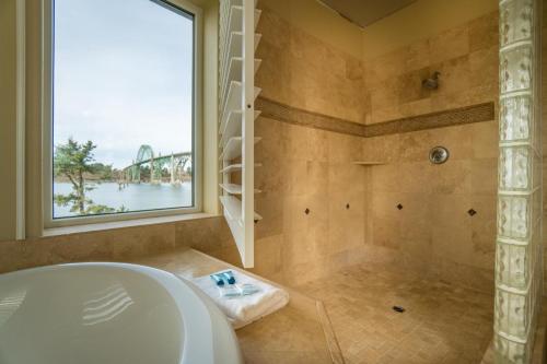 新港Windward at the Regatta的一间带浴缸和淋浴的浴室,并设有一个窗户