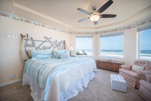 新港Beverly Beach Overlook的一间卧室配有一张床、风扇和椅子