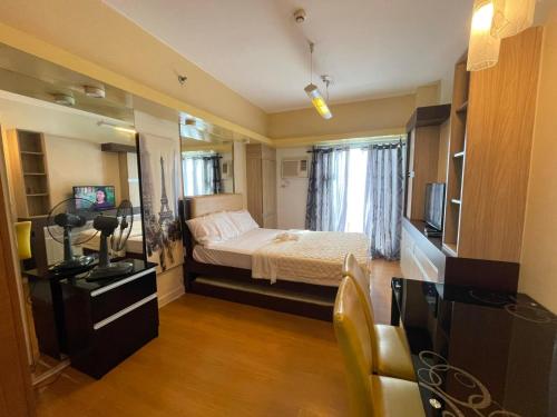 马尼拉8 Adriatico的小房间设有床和电视