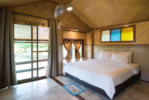 Ban Mae La Noiเฮินไต รีสอร์ท แม่ลาน้อย的一间卧室设有一张大床和一个窗户。