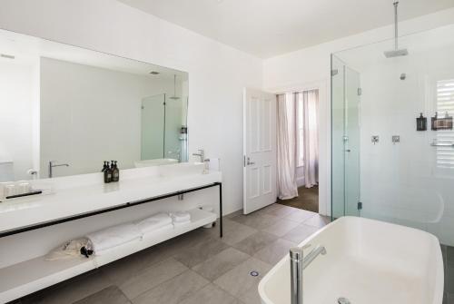 斯特灵The Stirling Hotel的白色的浴室设有浴缸和水槽。