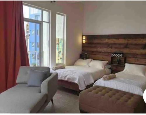 恩塞纳达港las palmas的一间卧室设有两张床、一张沙发和一个窗口