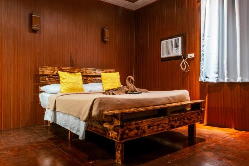 长滩岛Frendz Hostel Boracay的一间卧室配有一张带黄色枕头的床
