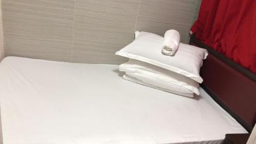 香港金源賓館 Golden Yuan Guest House的一张带白色枕头的床和毛巾