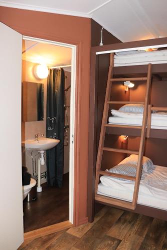 布罗斯Borås Camping & Vandrahem的配有水槽和镜子的客房内的双层床
