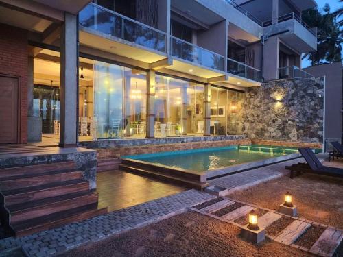 马拉维拉Adique's Resorts的一座房子前面设有游泳池