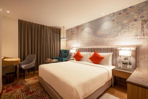 博帕尔Golden Tulip Bhopal的酒店客房设有一张大床和一张书桌。