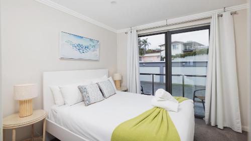 One MileOn the Beach Getaway的卧室配有白色的床和窗户。