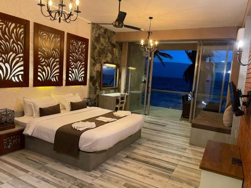 马拉维拉Adique's Resorts的一间卧室配有一张床,享有海景