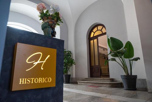 特拉帕尼Historico Loft & Rooms Palazzo Adragna XIX的植物建筑的大厅里的一个标志
