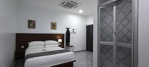 阿罗士打Padi Hotel Alor Setar的一间卧室设有一张床和一个滑动玻璃门