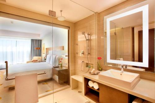 博帕尔博帕尔万怡酒店 的浴室设有床、水槽和镜子