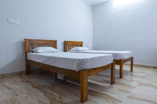 马尼帕尔Rashra Residency的双床间,铺有木地板