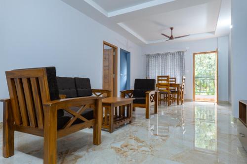 马尼帕尔Rashra Residency的客厅配有椅子和桌子