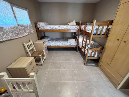 Finca Aideta- casa confortable con barbacoa的客房设有两张双层床,铺有瓷砖地板。