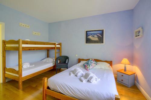 圣洛贝斯LA DEMEURE - Incroyable maison en bord de Dordogne的一间卧室配有两张床和一张双层床。