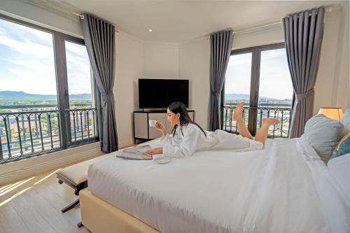 洞海Rex Quang Binh Hotel的躺在旅馆房间床上的女人