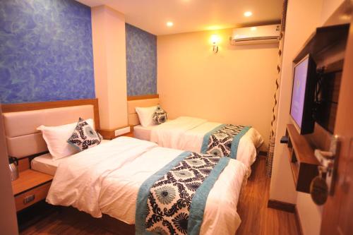 加德满都Hotel Arati Pvt. Ltd.的酒店客房设有两张床和一台平面电视。