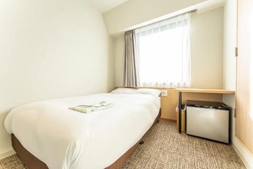浦安CVS海湾酒店的卧室设有一张白色大床和一扇窗户。