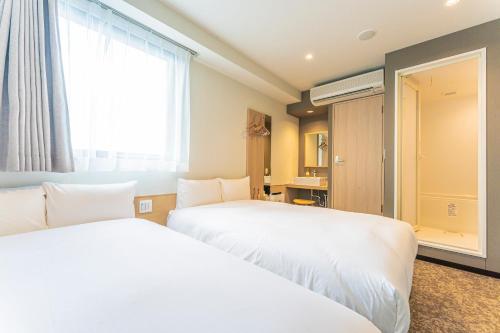 浦安CVS海湾酒店的酒店客房设有两张床和窗户。