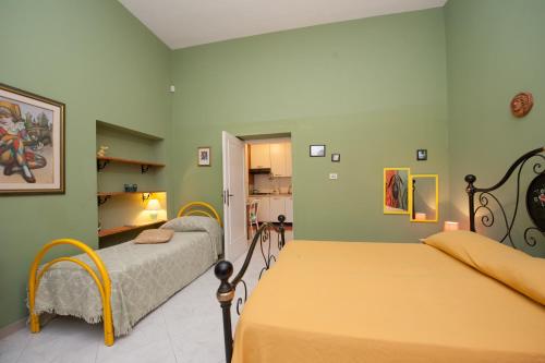 纳尔多B&B Le 4 Stagioni的绿墙客房内的两张床
