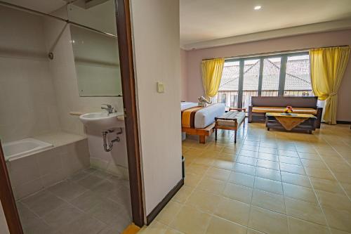 登巴萨Grand Santhi Hotel的一间酒店客房 - 带一张床和一间浴室
